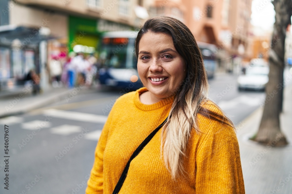 Young beautiful plus size woman smiling confident looking to the side at street Young beautiful plus size woman smiling confident looking to the side at street