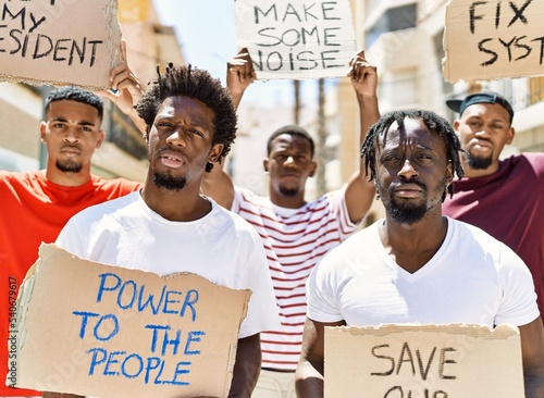 Photographie Group of young african american activists holding protest banner protesting at the city