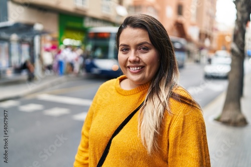 Young beautiful plus size woman smiling confident looking to the side at street © Krakenimages.com