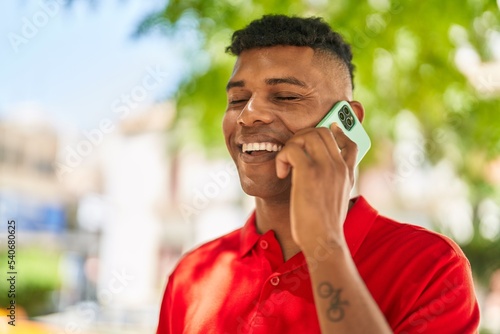 Young latin man smiling confident talking on the smartphone at park