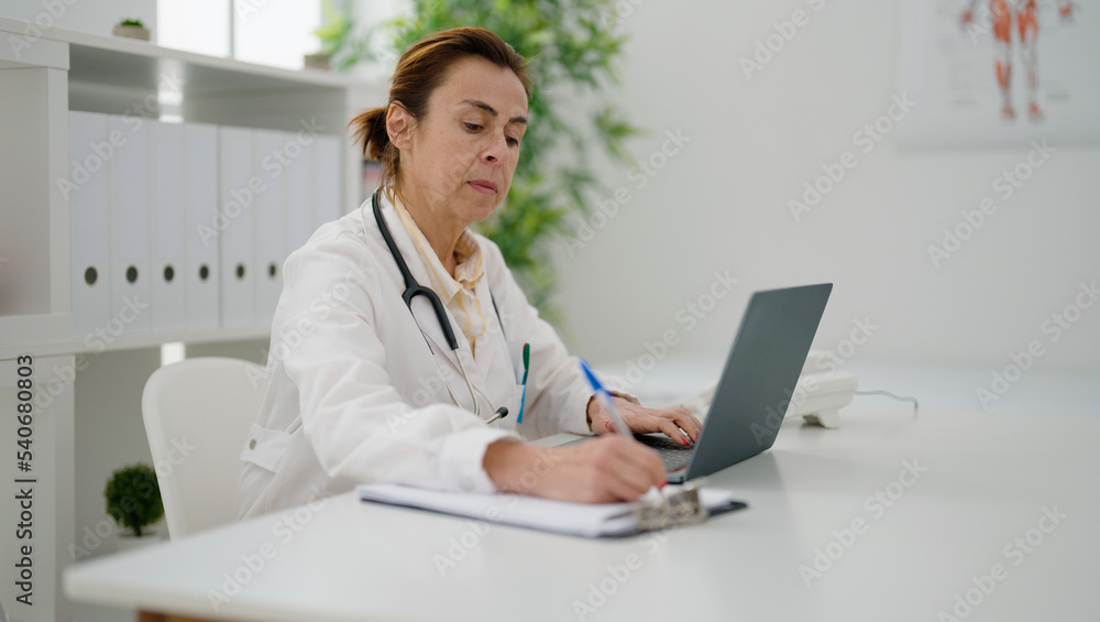Middle age hispanic woman wearing doctor uniform working at clinic Middle age hispanic woman wearing doctor uniform working at clinic