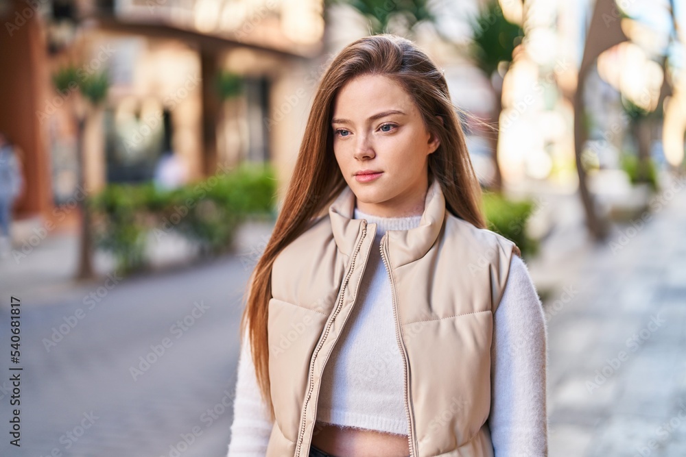 Fototapeta premium Young blonde woman with relaxed expression standing at street
