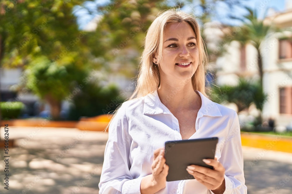 Young blonde woman smiling confident using touchpad at park Young blonde woman smiling confident using touchpad at park