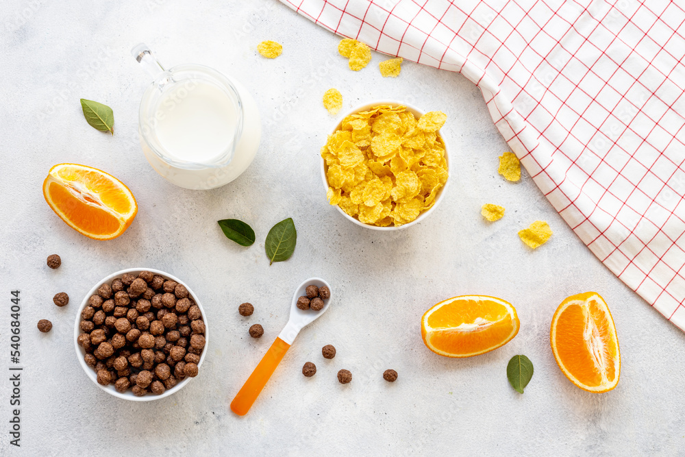 Kids breakfast with corn flakes, milk and orange, top view Kids breakfast with corn flakes, milk and orange, top view