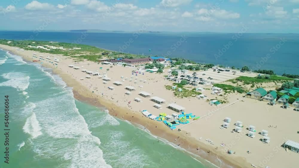 Aerial over the long sandy spit with a beach and azure water on a sunny summer day. Waves crashing to the shore. Relaxing calm atmosphere Aerial over the long sandy spit with a beach and azure water on a sunny summer day. Waves crashing to the shore. Relaxing calm atmosphere