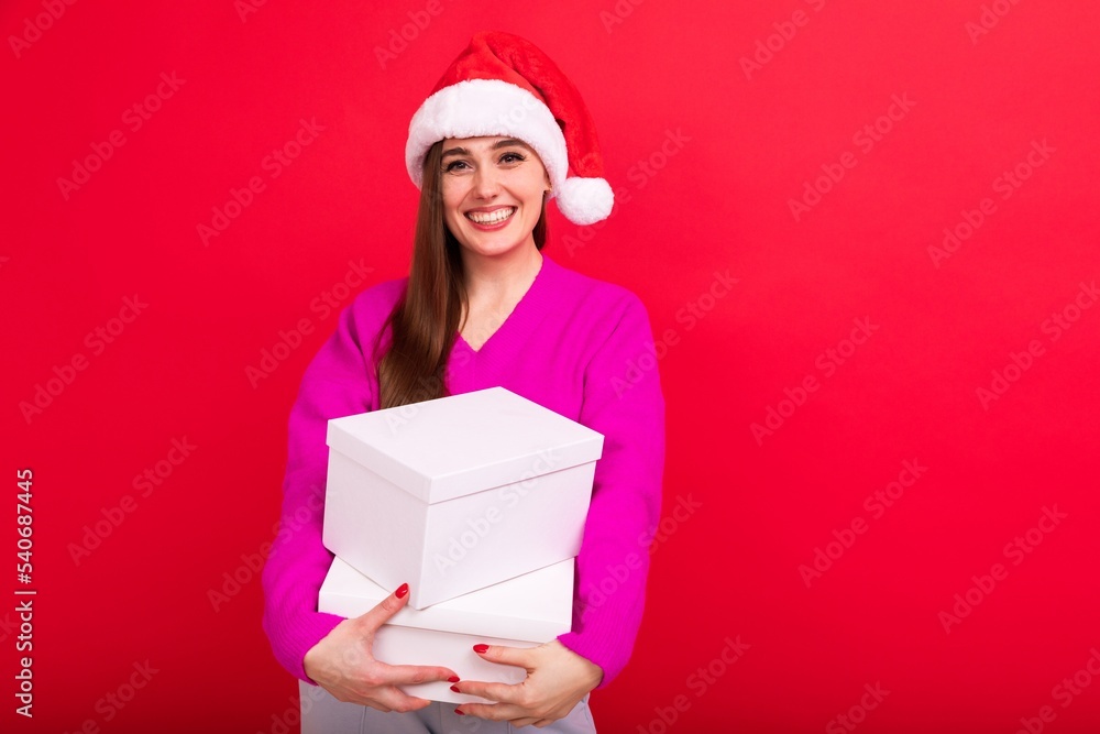 A young woman holds boxes with gifts on a red background. Christmas holidays with family A young woman holds boxes with gifts on a red background. Christmas holidays with family