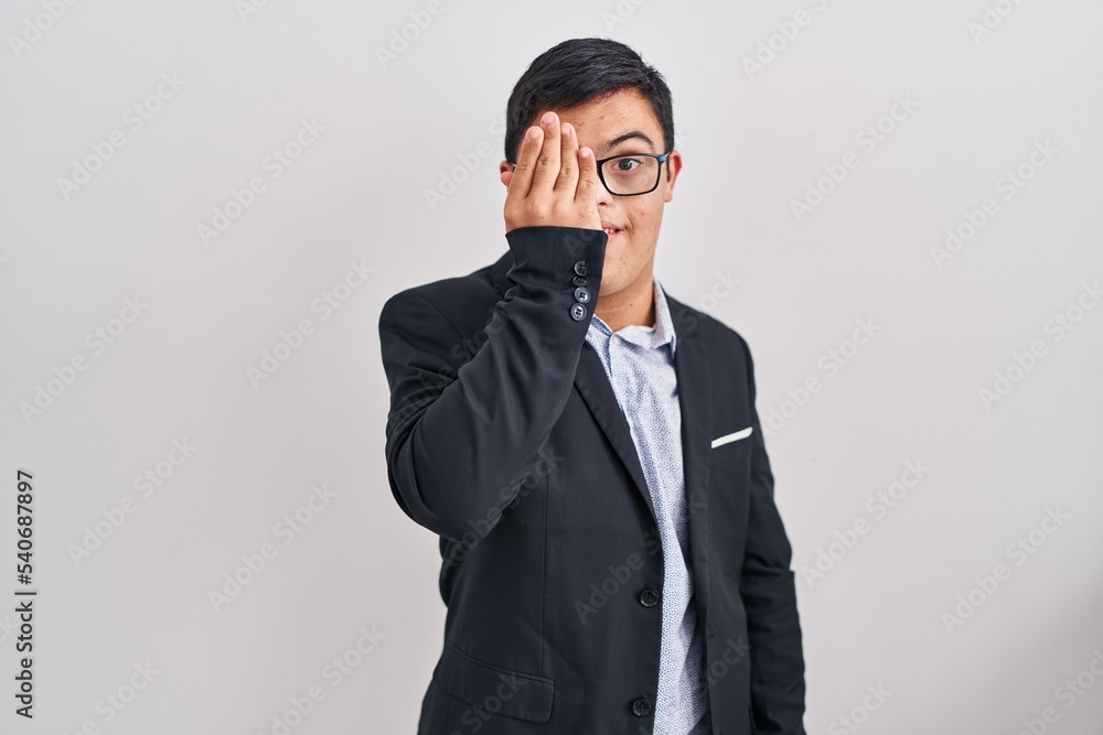 Young hispanic man with down syndrome wearing business style covering one eye with hand, confident smile on face and surprise emotion. Young hispanic man with down syndrome wearing business style covering one eye with hand, confident smile on face and surprise emotion.
