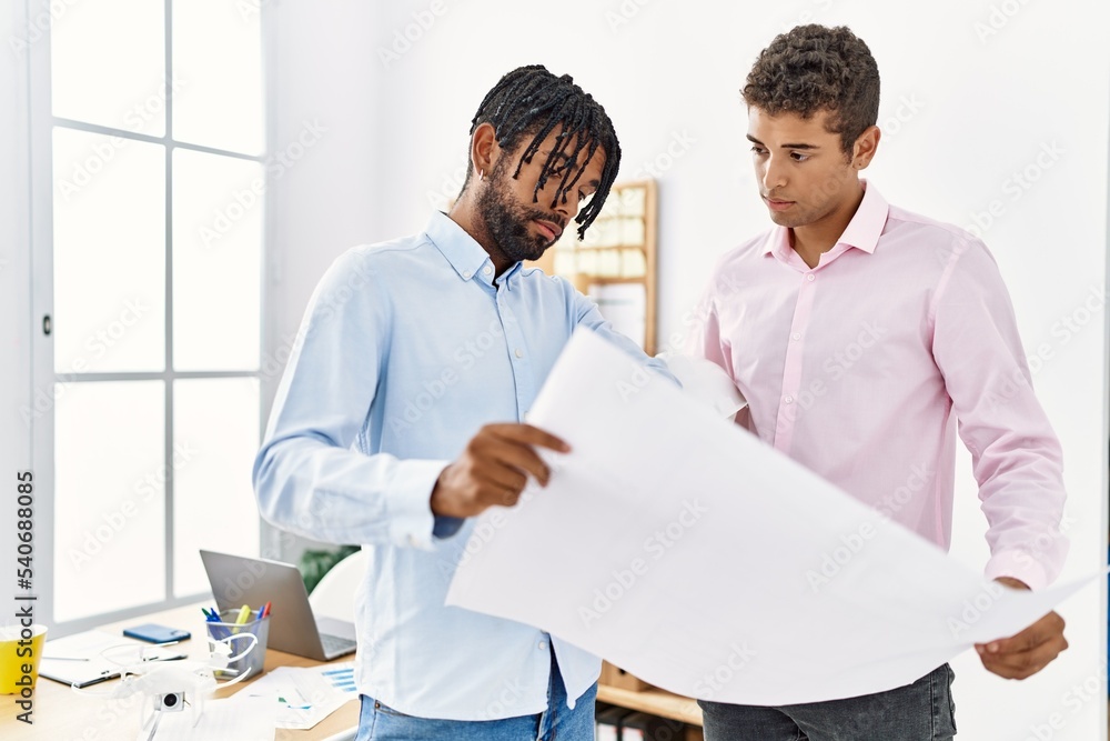 Two men architect workers looking blueprint standing at architecture studio Two men architect workers looking blueprint standing at architecture studio