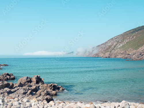 Summer day with fog in Moreira beach in Muxia, Costa da Morte, Galicia, Spain. This beach is one of the wildest spots on the hiking trail called 