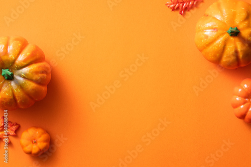 Creative Halloween design concept background with pumpkin, autumn leaves and copy space.