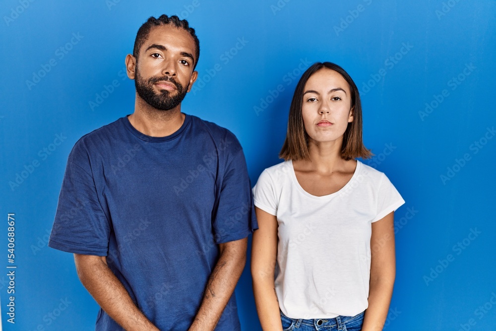 Young hispanic couple standing together relaxed with serious expression on face. simple and natural looking at the camera. Young hispanic couple standing together relaxed with serious expression on face. simple and natural looking at the camera.