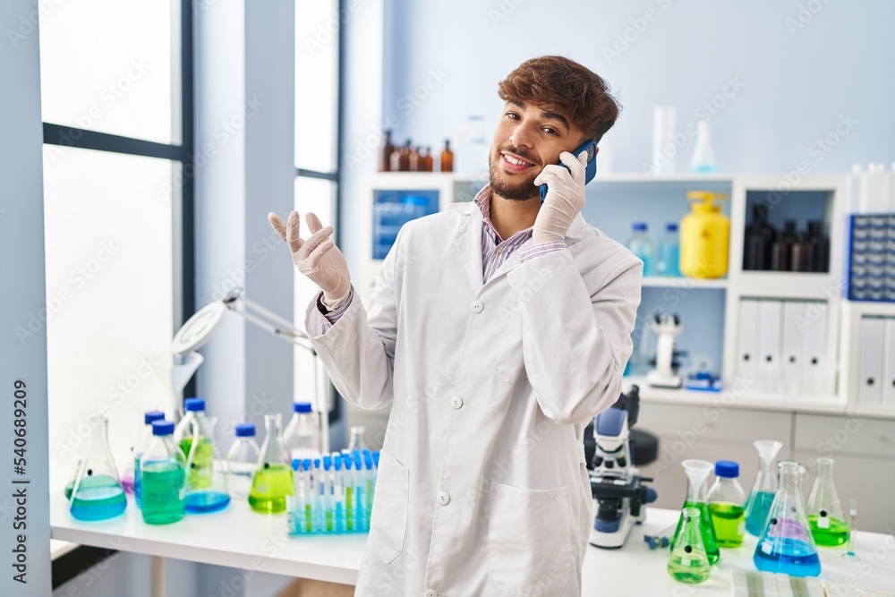 Young arab man scientist smiling confident talking on smartphone at laboratory Young arab man scientist smiling confident talking on smartphone at laboratory