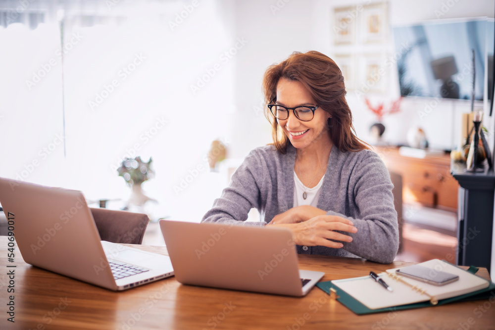 Confident woman using laptops while working from home Confident woman using laptops while working from home