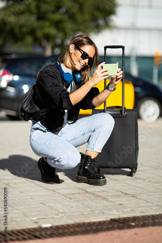 smiling woman taking photo with mobile phone