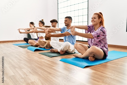 Group of young people training yoga at sport center.