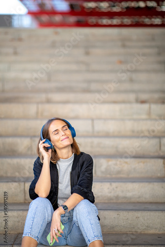 happy woman enjoying music with headphones and cellphone