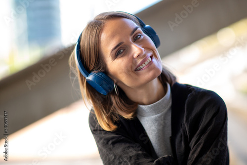 Close up smiling woman listening to music with headphones