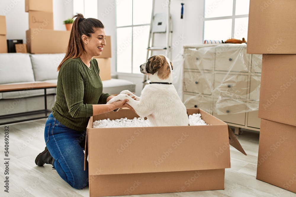 Young woman smiling confident playing with dog at home Young woman smiling confident playing with dog at home