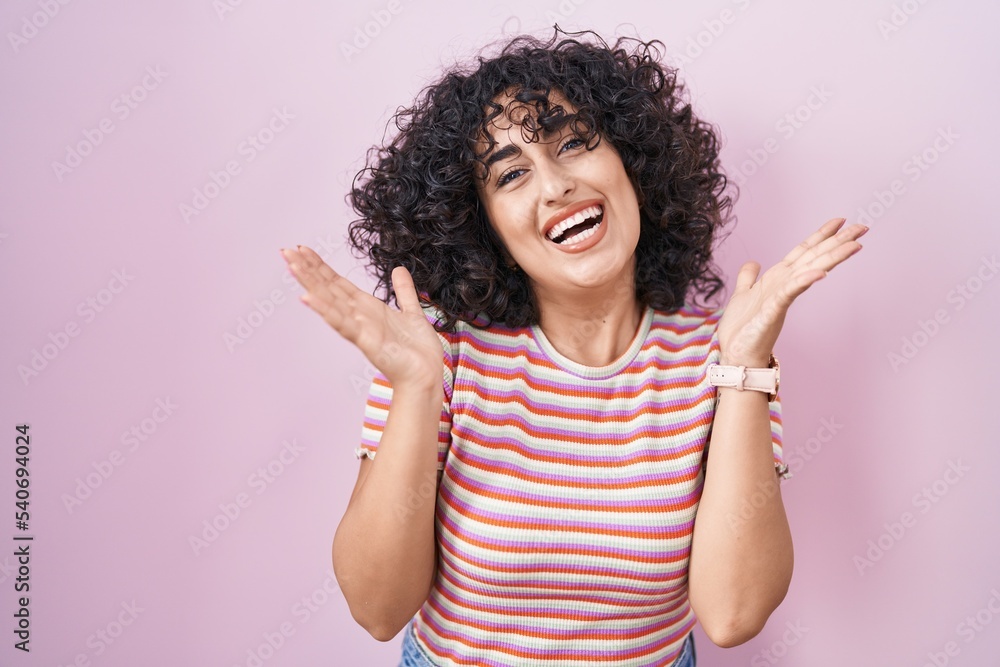 Young middle east woman standing over pink background celebrating crazy and amazed for success with arms raised and open eyes screaming excited. winner concept Young middle east woman standing over pink background celebrating crazy and amazed for success with arms raised and open eyes screaming excited. winner concept