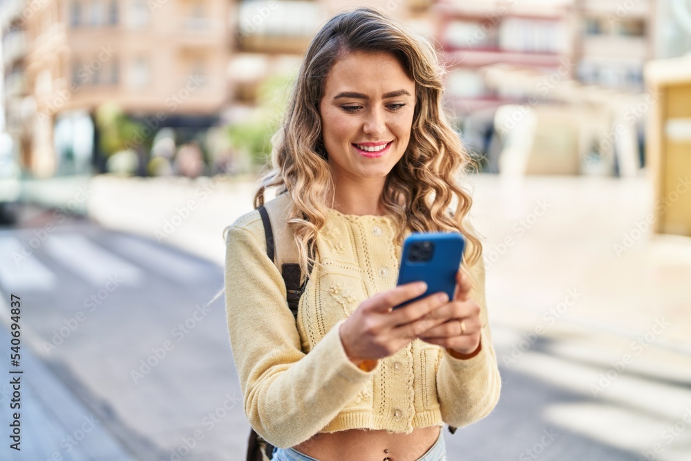 Young woman tourist smiling confident using smartphone at street Young woman tourist smiling confident using smartphone at street