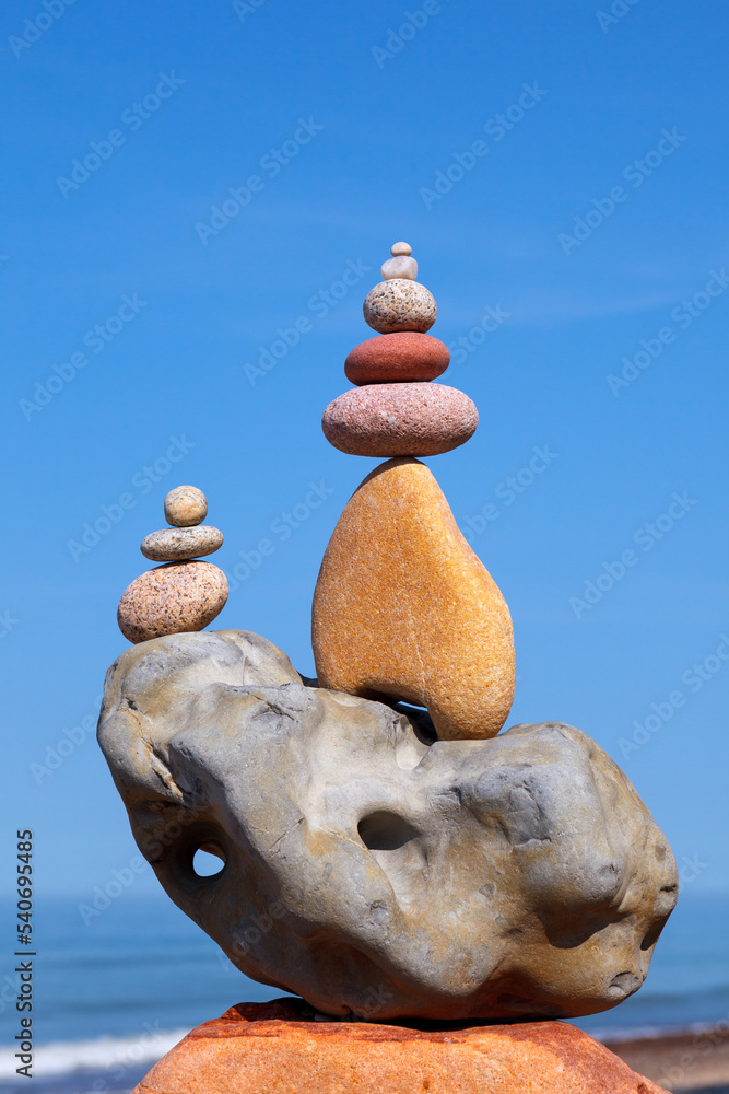 Rock zen pyramid of stones of different shapes on a background of blue ...