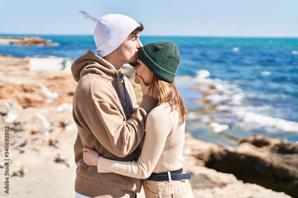 Mand and woman couple hugging each other and kissing at seaside
