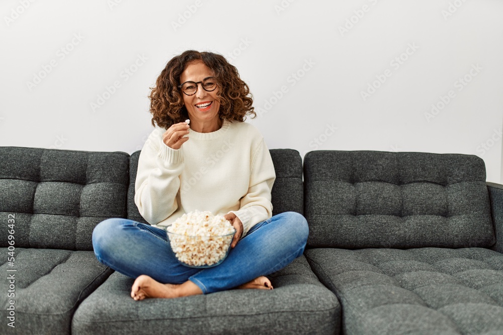 Middle age hispanic woman smiling confident watching movie at home Middle age hispanic woman smiling confident watching movie at home