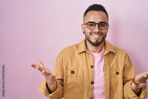 Young hispanic man standing over pink background celebrating crazy and amazed for success with arms raised and open eyes screaming excited. winner concept © Krakenimages.com