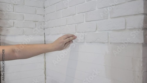 laying decorative embossed gypsum bricks on the wall. Modern apartment renovation photo