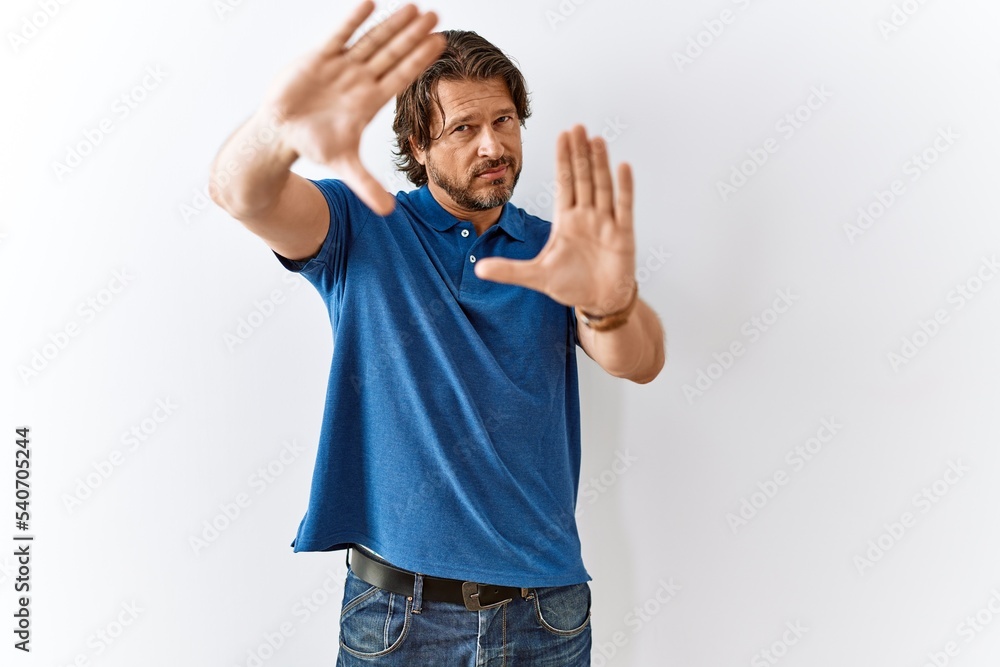 Handsome middle age man standing together over isolated background doing frame using hands palms and fingers, camera perspective Handsome middle age man standing together over isolated background doing frame using hands palms and fingers, camera perspective