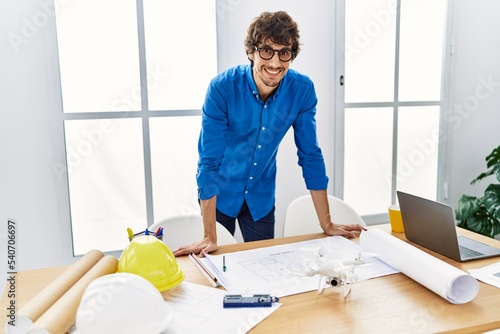 Young hispanic man smiling confident working at architecture studio