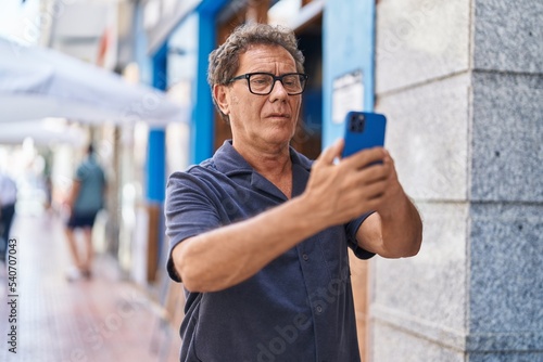 Middle age man making selfie by the smartphone at street