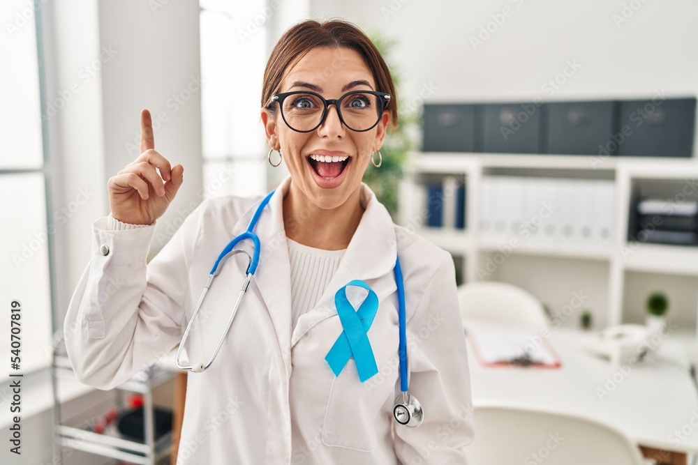 Young brunette doctor woman wearing stethoscope at the clinic pointing finger up with successful idea. exited and happy. number one. Young brunette doctor woman wearing stethoscope at the clinic pointing finger up with successful idea. exited and happy. number one.