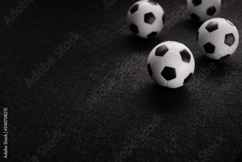 Several classic soccer balls on a dark background.