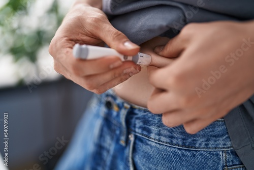 Young caucasian man measuring glucose standing at home