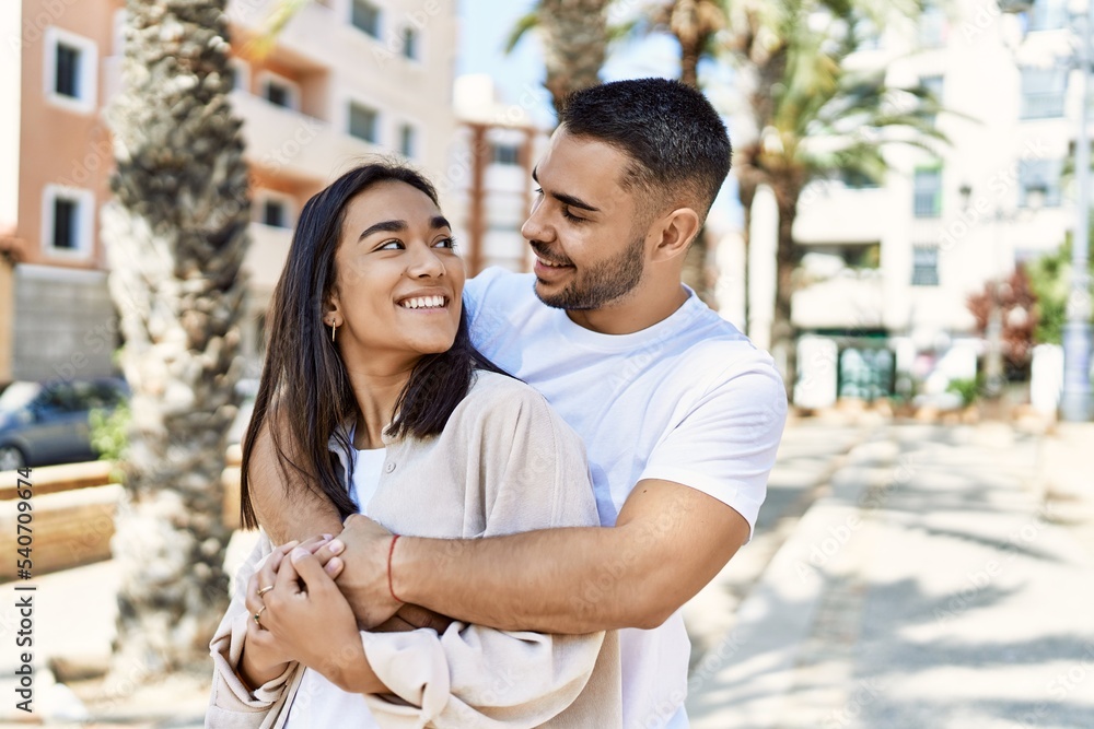 Young latin couple smiling happy and hugging at the city. Young latin couple smiling happy and hugging at the city.