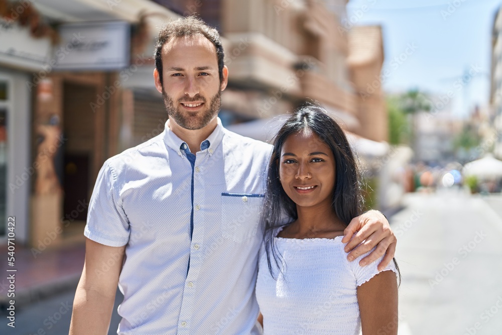 Man and woman interracial couple hugging each other at street Man and woman interracial couple hugging each other at street