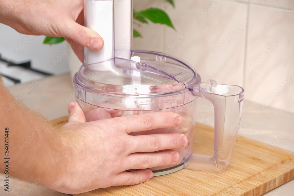 Food processor with pieces chicken breast. Process of cooking chicken