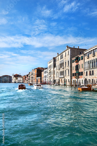 Grand Canal in Venice. Architecture of Venice, Italy. Palazzo and historic houses in the water. Traditional Venetian architecture and boat traffic along Grand Canal in Veneto.