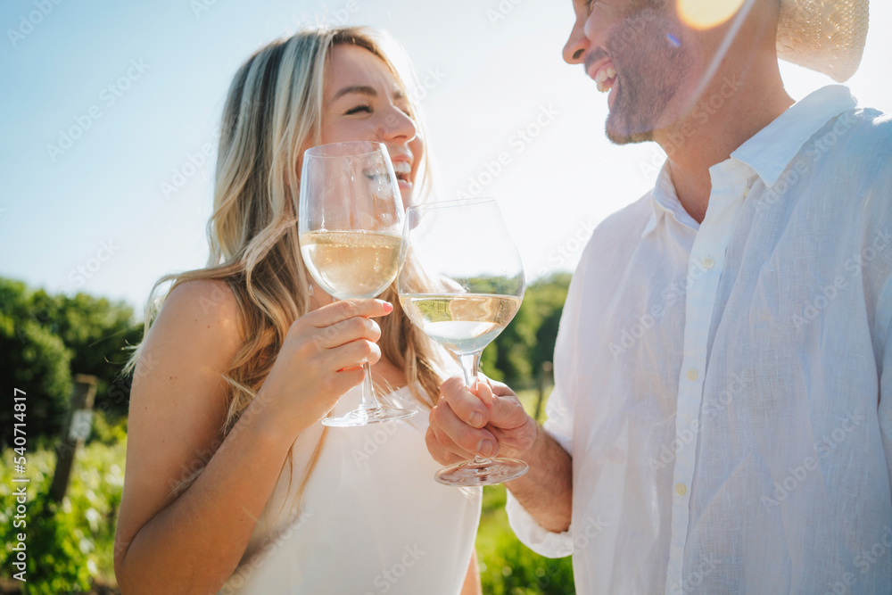 Happy couple toasting wine at winery on sunny day Happy couple toasting wine at winery on sunny day