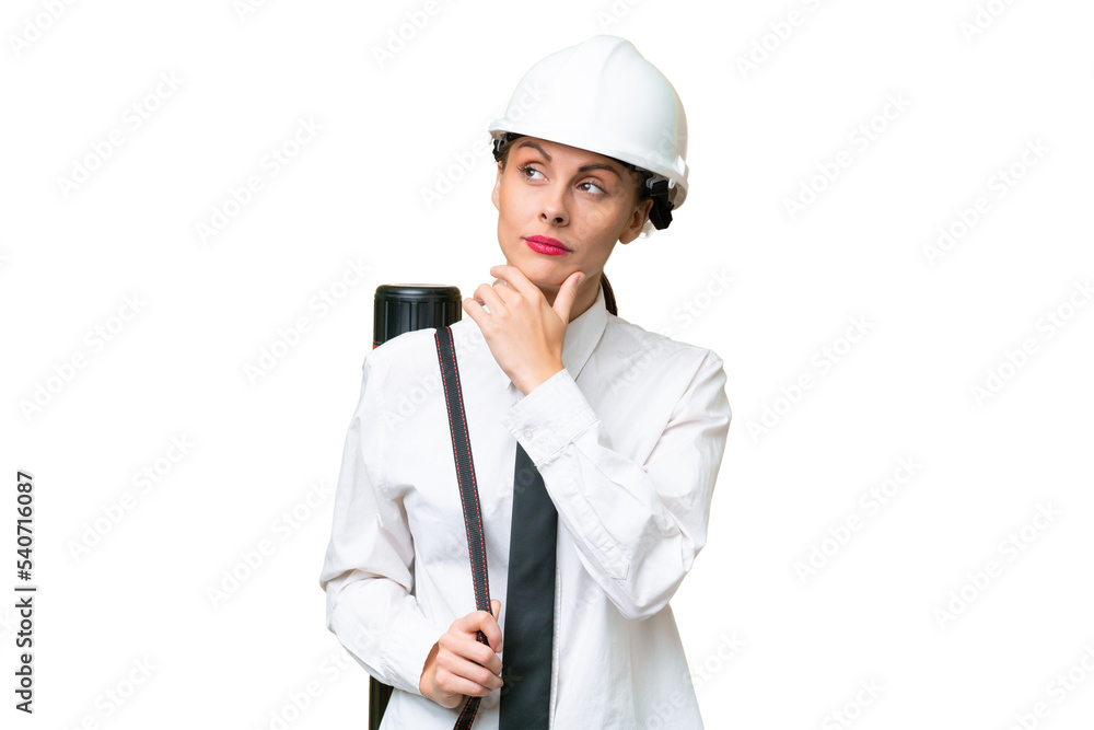 Young architect woman with helmet and holding blueprints over isolated background and looking up Young architect woman with helmet and holding blueprints over isolated background and looking up