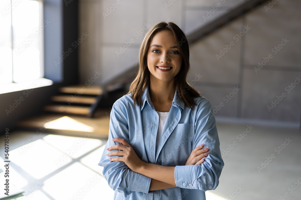 Portrait of beautiful young woman smiling with arms crossed at home Portrait of beautiful young woman smiling with arms crossed at home