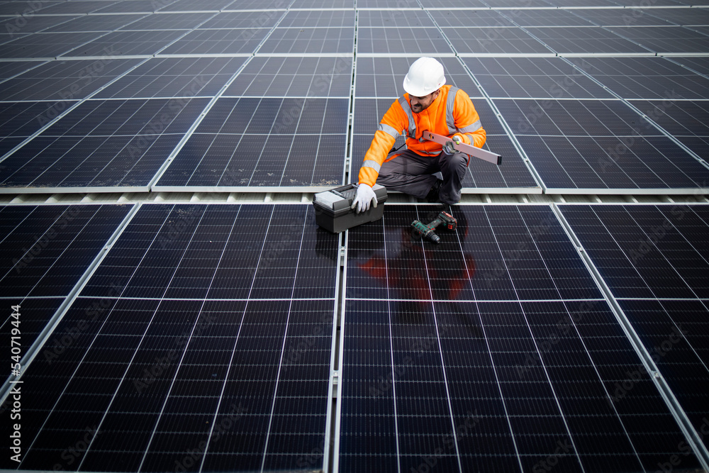Top view of solar energy worker installing photovoltaic panels on the roof. Top view of solar energy worker installing photovoltaic panels on the roof.
