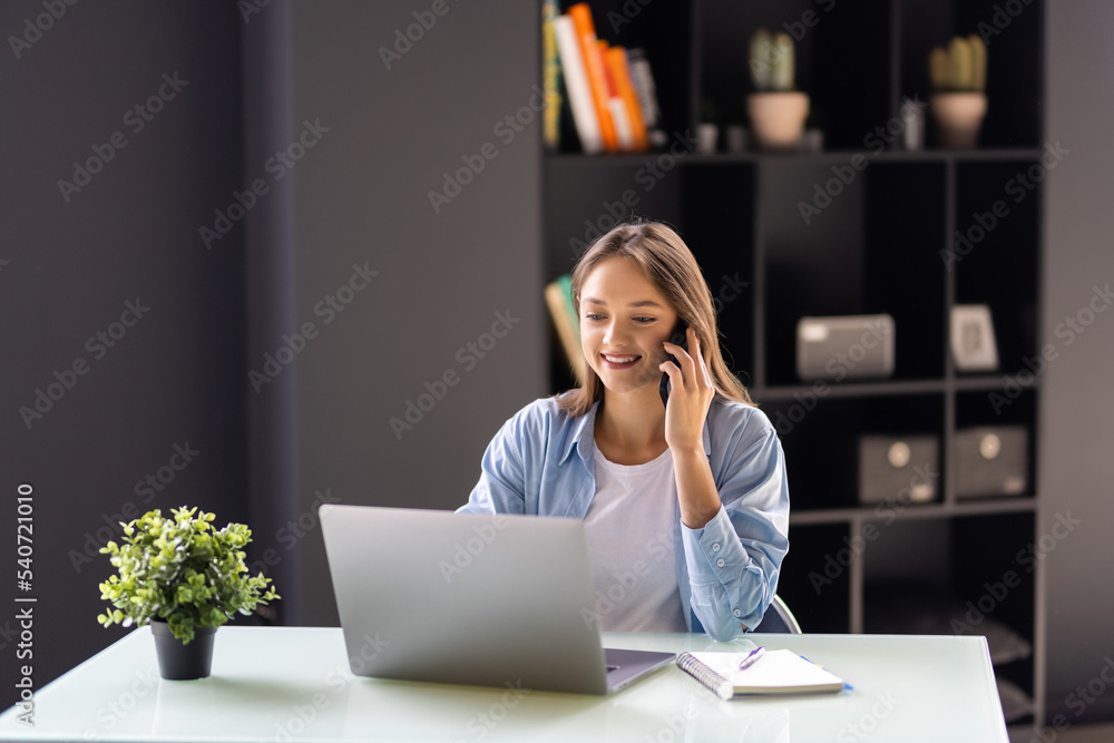 Beautiful successful woman talking on phone at the modern office Beautiful successful woman talking on phone at the modern office