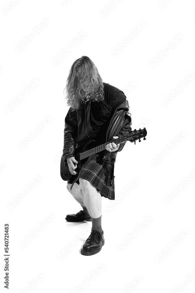 Portrait of expressive young man with long hair, rock musician playing guitar over white background. Black and white photography Portrait of expressive young man with long hair, rock musician playing guitar over white background. Black and white photography
