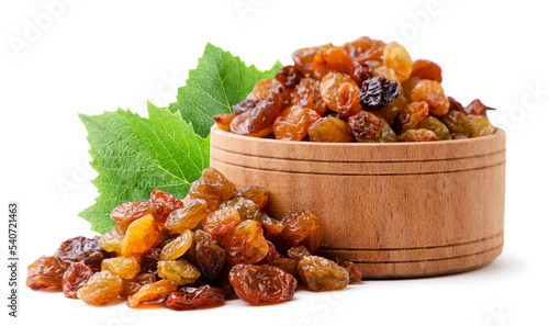 Raisins in a wooden plate with leaves close-up on a white background. Isolated