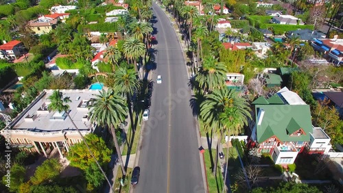 Aerial Tilt Up Shot Of Cars Moving On Road In Residential City - Beverly Hills, California