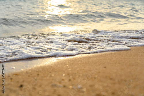 Seawater soft wave crashing on sandy beach seaside in summer on sunset time. summer vacation activity background concept..