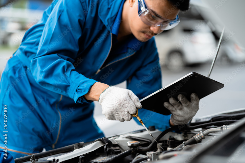 Car repair service by professional mechanics and car engine check in the garage. Professional mechanic working in the garage.Car maintenance concept and garage service. Professional service concept. Car repair service by professional mechanics and car engine check in the garage. Professional mechanic working in the garage.Car maintenance concept and garage service. Professional service concept.