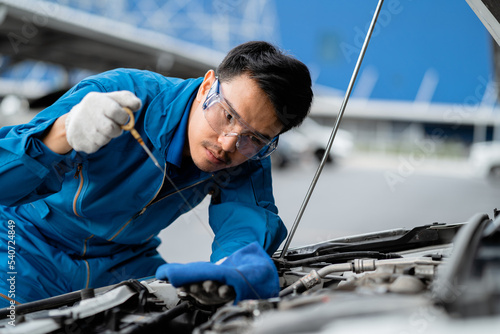 Auto mechanic concept.  Asian mechanics are using tools to check car safety in garage, maintenance of damaged parts in garage. Maintenance work. Concept of repair service.
